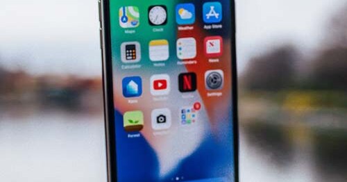 Persona usando una aplicación en su iPhone, ilustración del artículo con consejos para hacer una aplicación móvil